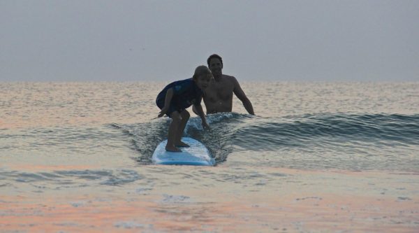 person learning how to surf using a surfboard