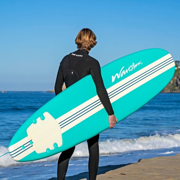man holding a surfboard and looking out into the ocean