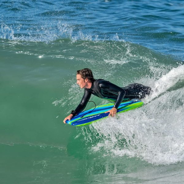 man riding a bodyboard down a wave tide