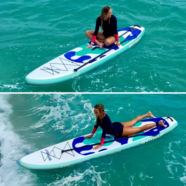 woman sitting and laying flat on a paddle board while sailing on the ocean